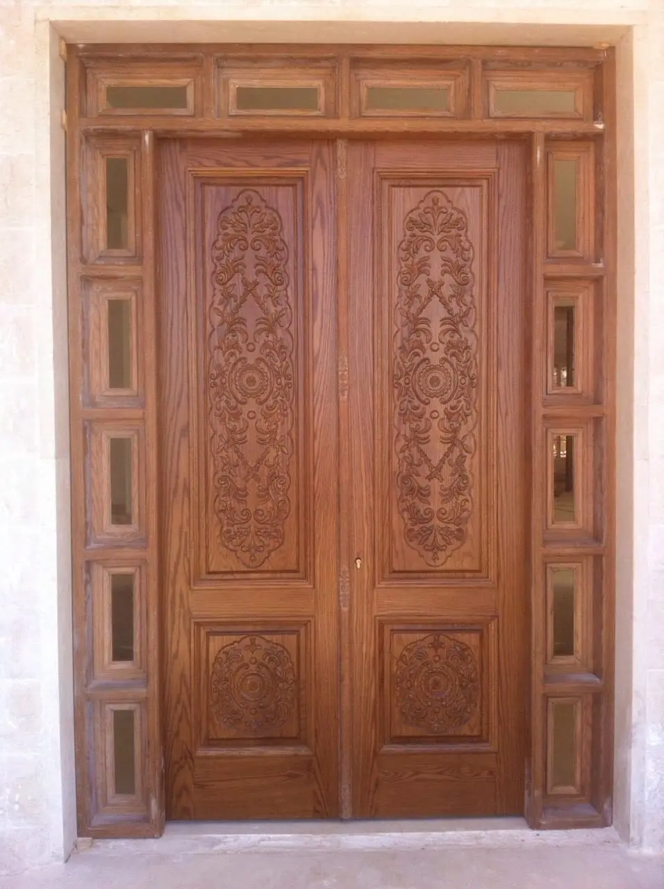 Carved double entrance door in timber with glazed side panels