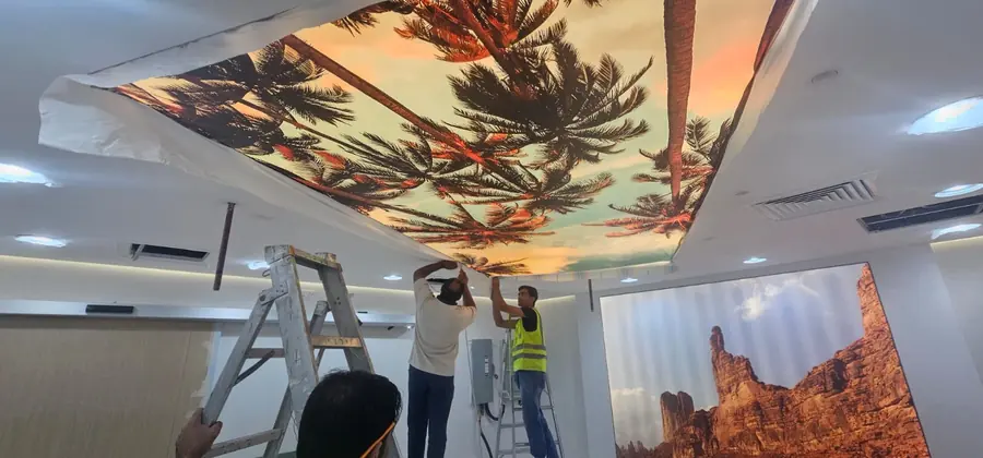 Technicians fitting a printed backlit ceiling panel above an imaging room
