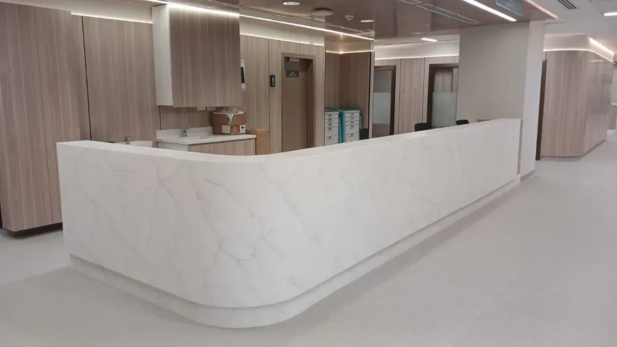 Curved nurse station in veined solid surface with timber-grain panels