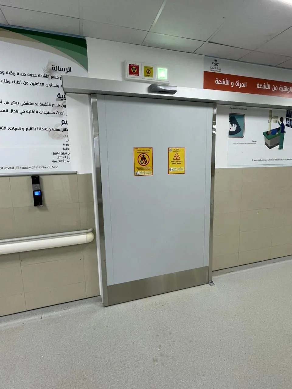 باب منزلق بلوحات تحذير من الإشعاع وقارئ بطاقات بجانبه