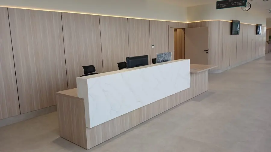 Reception counter in veined white solid surface and timber-grain panels