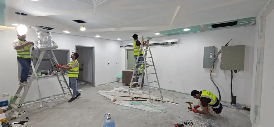 فنيون يركبون الخدمات ولوحة توزيع في غرفة جديدة